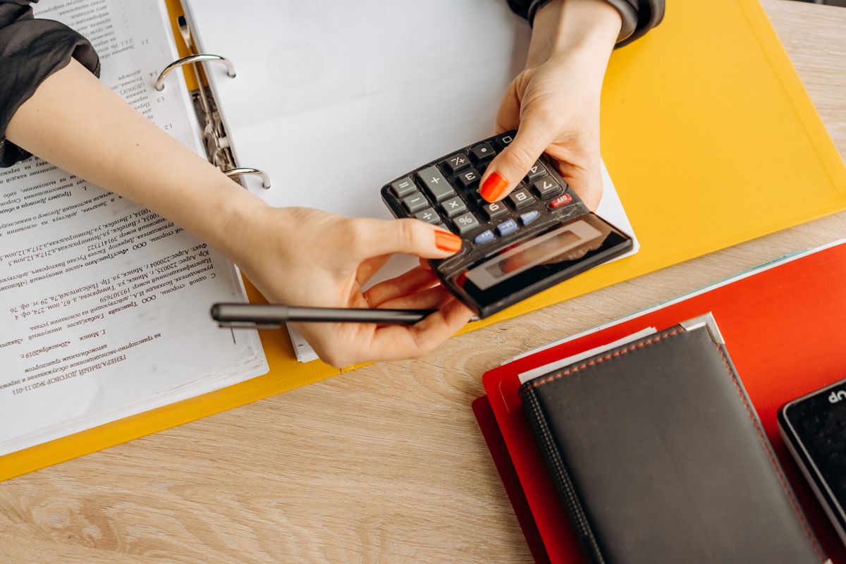 Hands using a calculator over financial paperwork