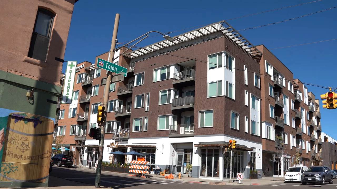 A mixed-use building with ground-floor storefronts on a street corner